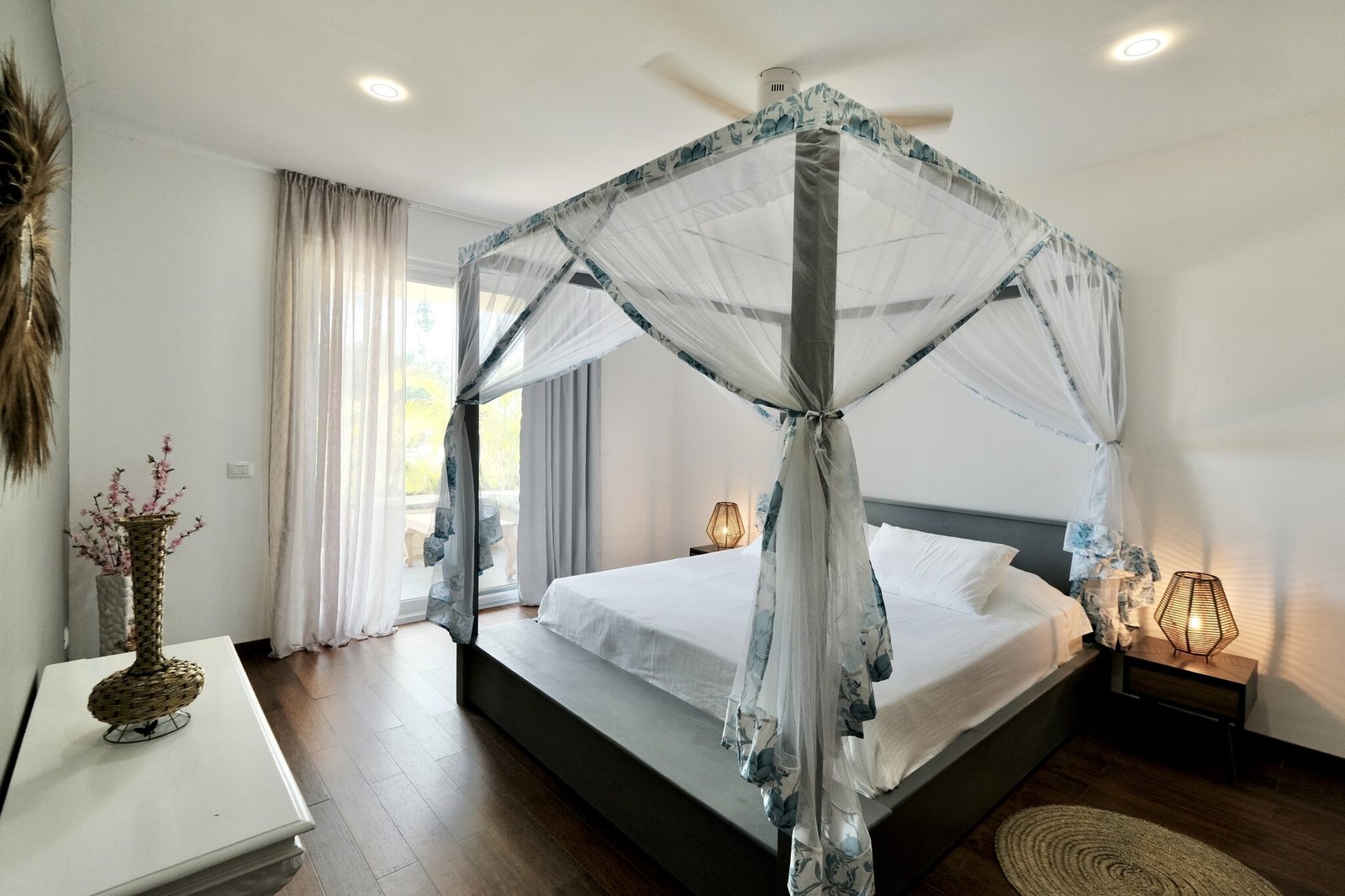 Deluxe Room interior with four-poster bed, mosquito net and garden view