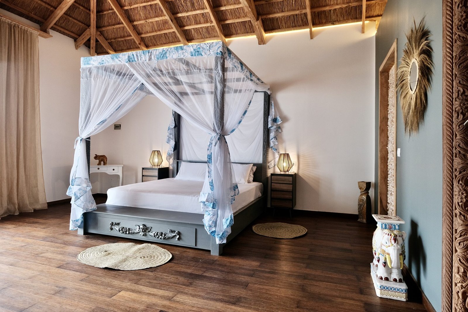 Luxury Villa bedroom with four-poster bed under a thatched roof